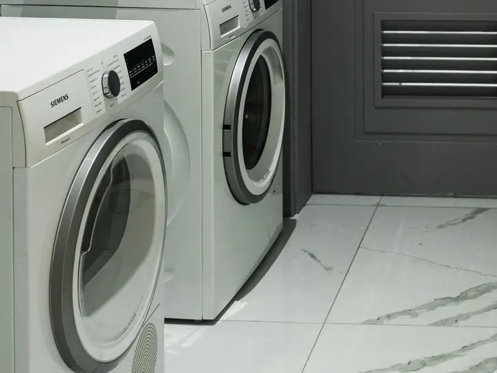 Homeowner following a washing machine maintenance checklist in a laundry room